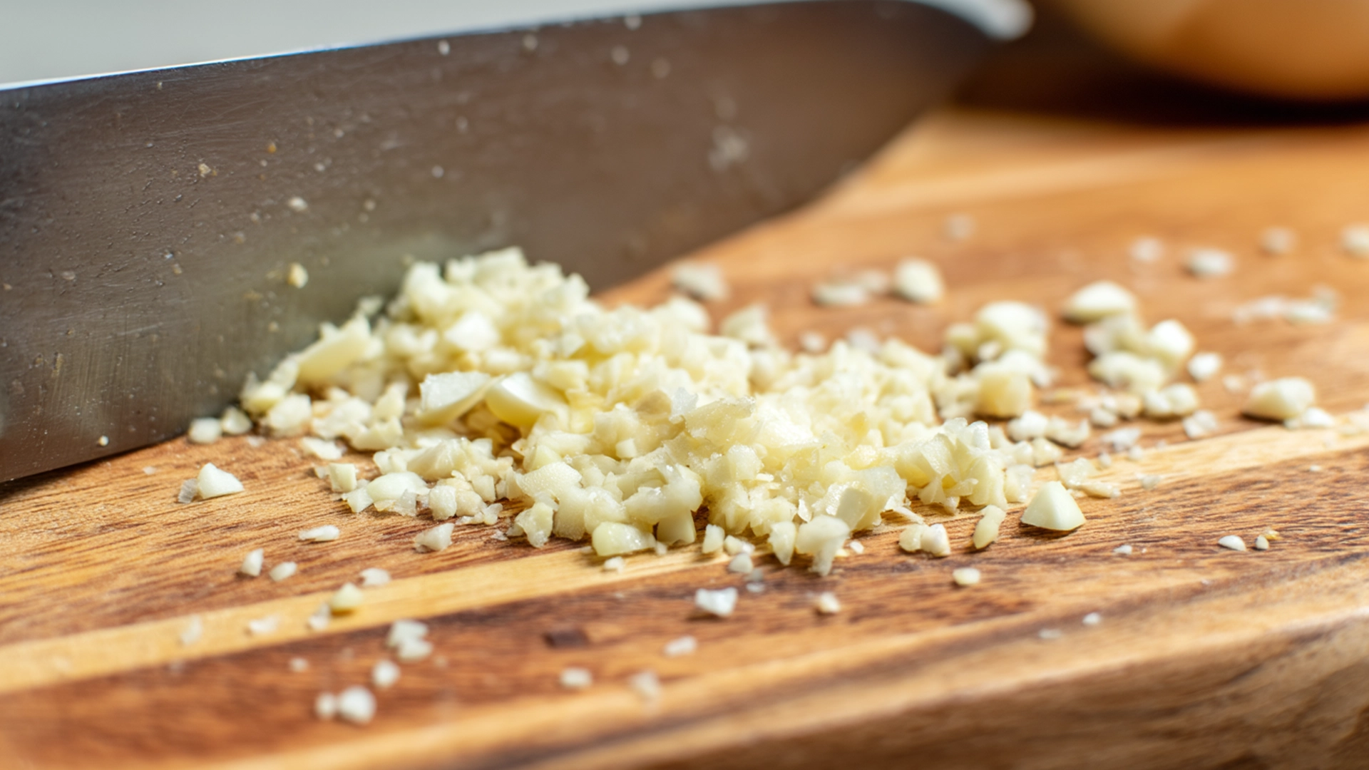 Мелко нарезанный чеснок на кухонной доске