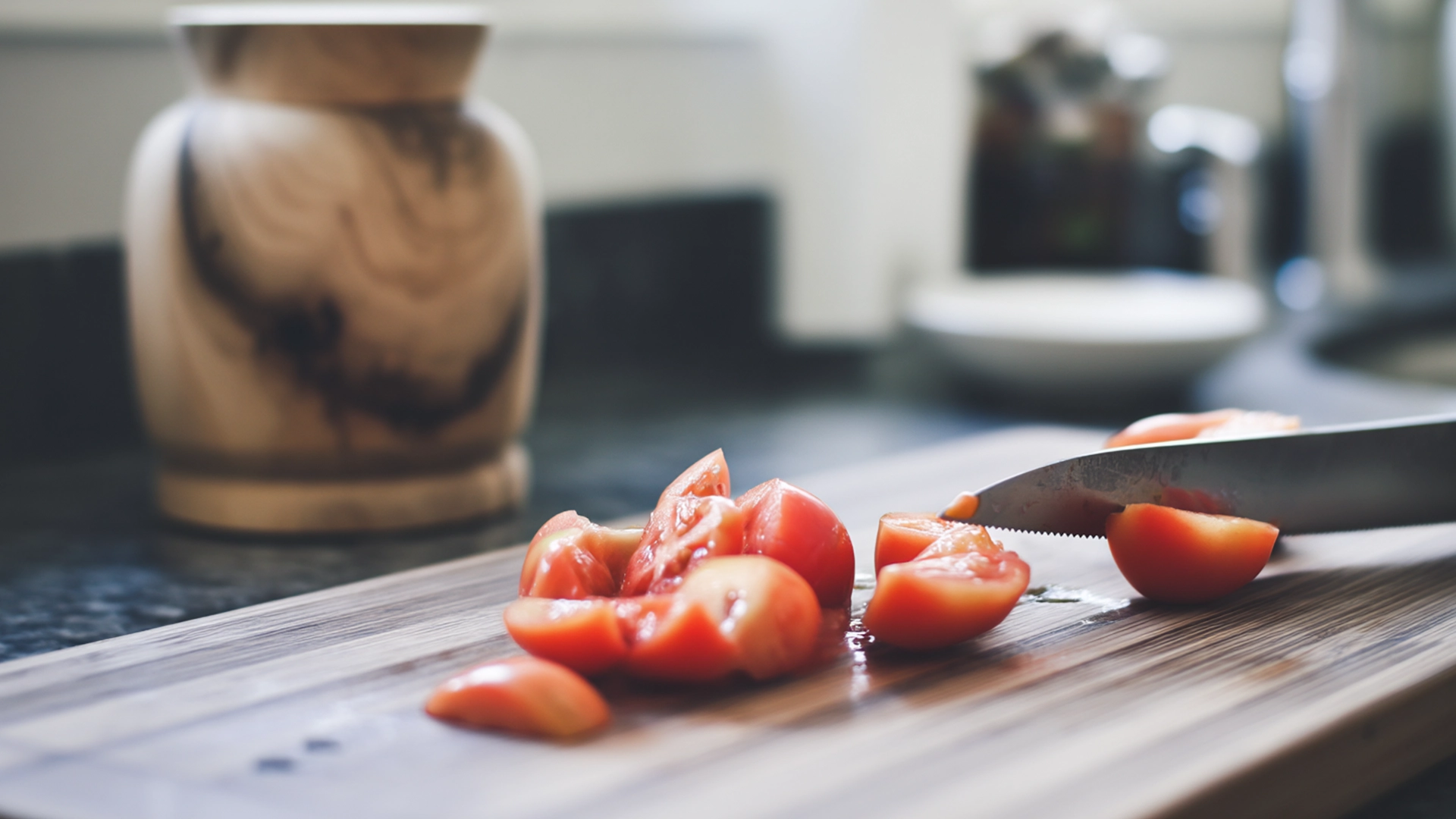 Нарезка помидоров на кухонной доске