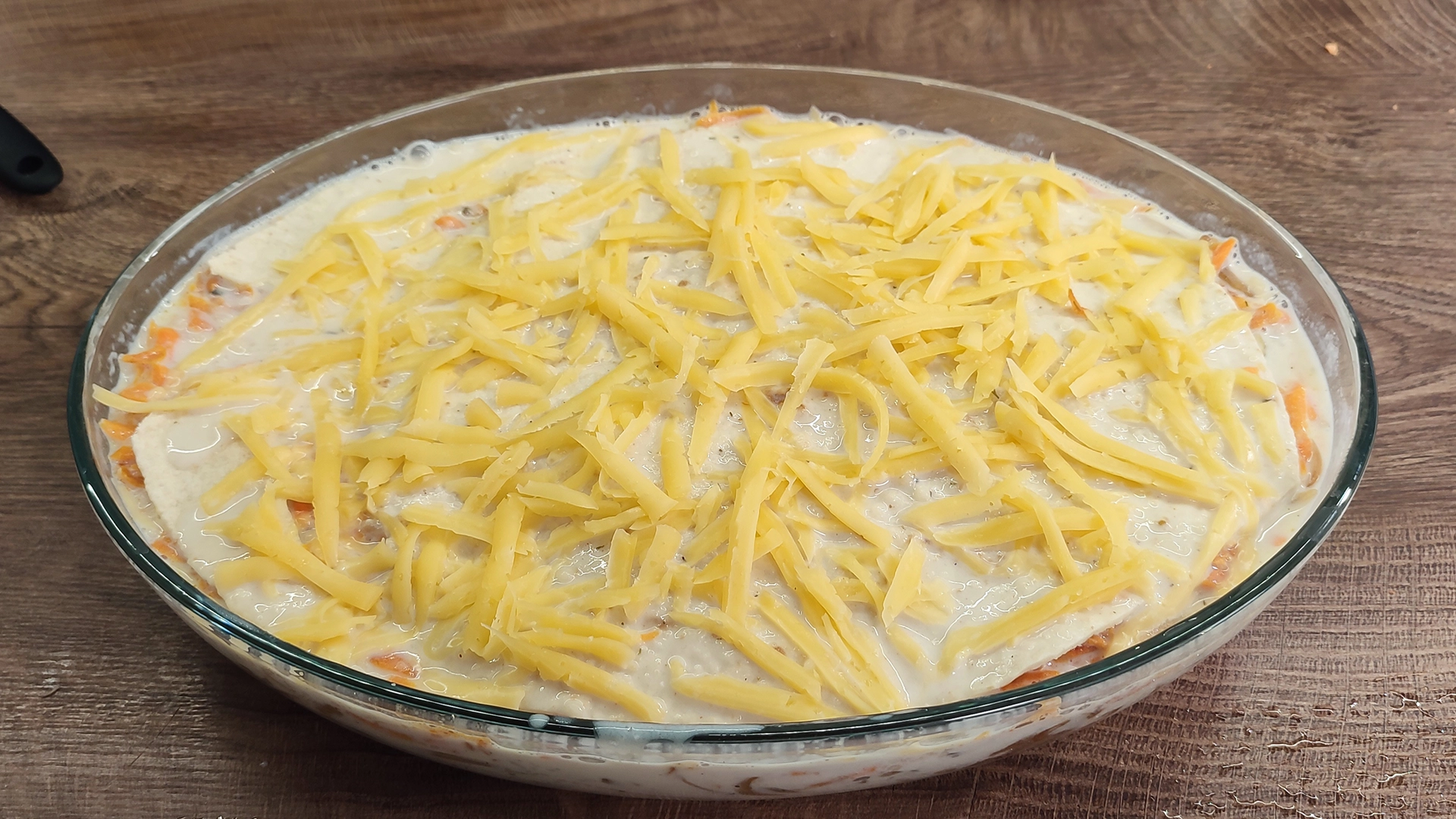 Залейте соусом и посыпьте сыром