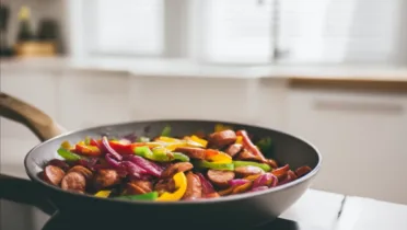 Фото блюда: Яркое овощное соте со шпикачками на сковороде