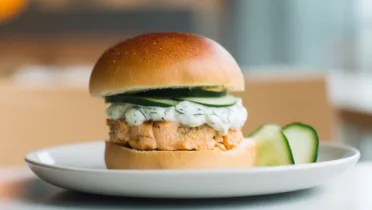 Фото рецепта Лососевый бургер с укропным соусом и огурцом