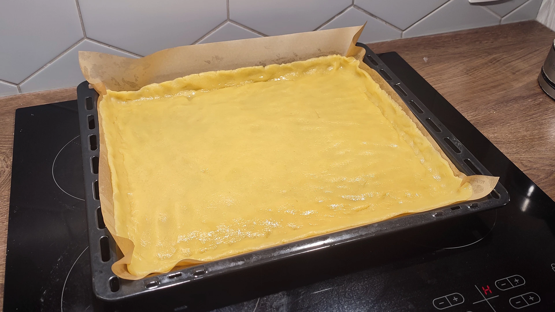 Песочное тесто разровнено в форме для выпечки