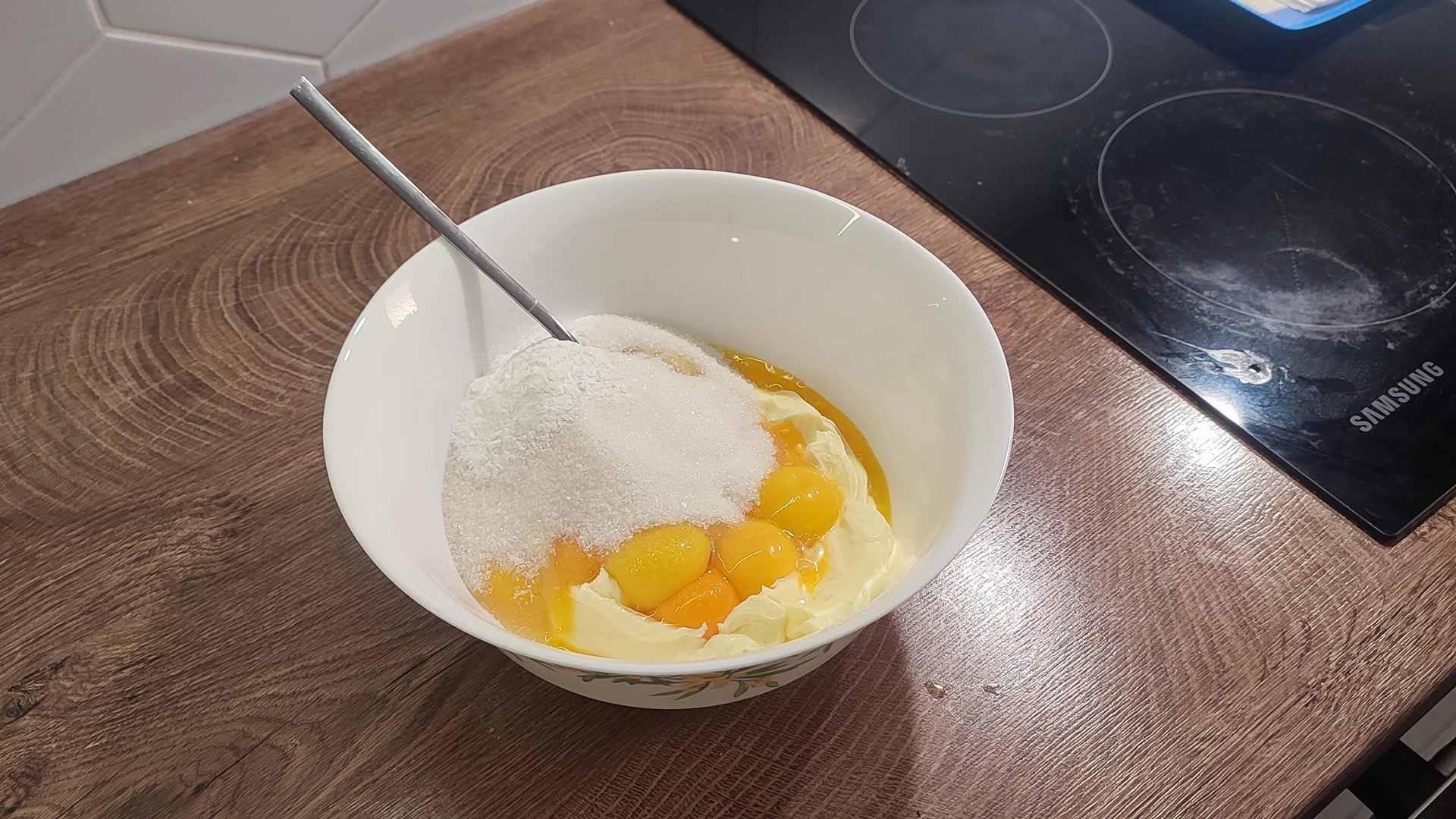 Желтки с сахаром и сливочным маслом в миске